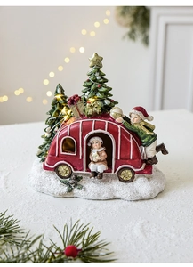 Detail of red resin Christmas camper with LED trees and realistic snow base