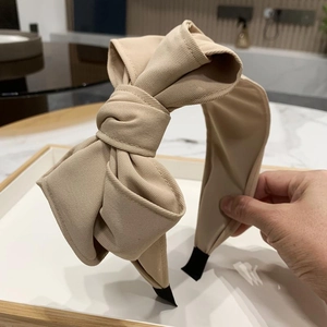 Detail of beige twill fabric multi-layer bow headband with elegant pleated texture