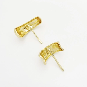 Close-up of elegant curved gold plated rectangular stud earrings on a white background