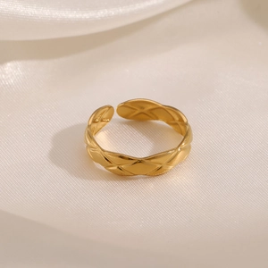 Minimalist gold plated stainless steel geometric ring with quilted pattern on white silk