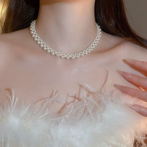 Close-up of double-layered pearl necklace on a model showing refined elegance and glow