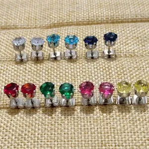 Gros plan de boucles d'oreilles clous en pierres précieuses avec serti à quatre griffes
