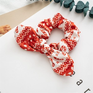 Detailed close-up of a festive Christmas bow scrunchie with red and white knit patterns