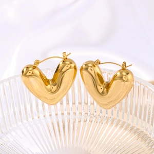 Minimalist 3D hollow heart earrings in gold plated finish displayed in glass