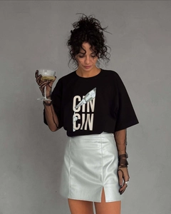 Détail de l'imprimé Cin Cin sur t-shirt noir ample avec une mini-jupe brillante