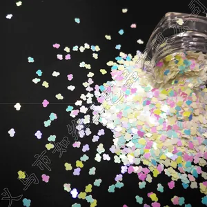 Macro shot of colorful cloud-shaped glitter sequins in a bottle for nail art and DIY craft