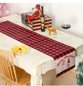 Detail of red and black buffalo plaid Christmas table runner with festive gnomes