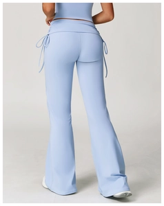 Rear view of high-waisted flared yoga pants in light blue featuring drawstring waist detail