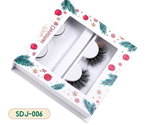 Detailed Christmas eyelash set with white feathers and dense black lashes in a festive box