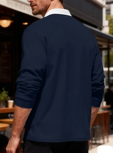 Detail of navy knit long-sleeve polo shirt with white contrast collar on a model