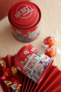 Detailed close-up of a red mini bunny tin box for tea storage with forest illustrations