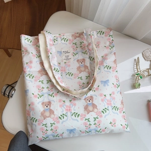 Détail de l'imprimé ours en peluche floral et étiquette sur le sac en coton blanc
