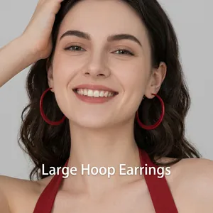 Close-up of a model wearing large red hoop earrings with a minimalist metallic finish