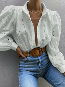 Close-up of white cotton linen shirt with embroidered eyelet detail and puff sleeves