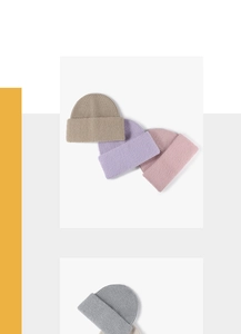 Close-up of assorted ribbed knit beanies in pastel colors showing soft fabric texture