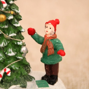 Vue détaillée de la figurine du Père Noël en résine avec sapin miniature et décorations