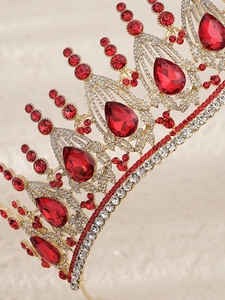 Macro detail of luxury baroque bridal crown with golden base and red teardrop rhinestones