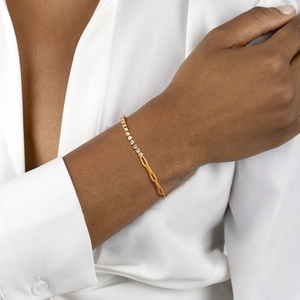 Detail of gold-plated chain bracelet with cubic zirconia paving on female wrist
