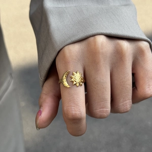 Detail of 18K gold-plated sun and moon open ring worn by a model on finger