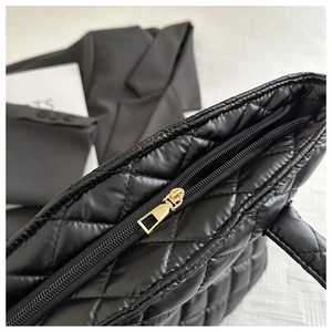 Gros plan sur un sac cabas matelassé noir avec une fermeture éclair en métal doré de qualité