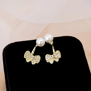 Detailed macro view of luxury bow pearl earrings with zircon inlay on a velvet box