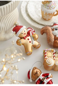 Detail view of golden Christmas ornaments featuring gingerbread man and squirrel figures