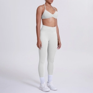 Dettaglio del set yoga bianco con reggiseno sportivo allacciato al collo e leggings
