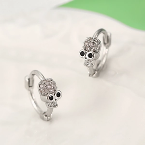Macro shot of silver skull earrings with black zircon eyes and sparkling pavé crystals