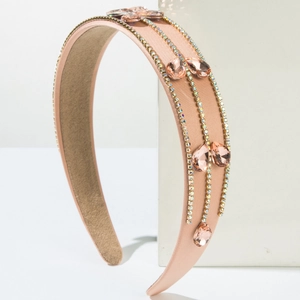 Detail of pink satin headband with rows of sparkling crystals and rhinestone chains