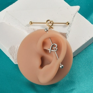 Detail eines 16g Industrial-Barbell aus Edelstahl mit hohlem Herz-Kreuz-Design für das Ohr