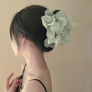 Vista dettagliata del fermaglio per capelli a fiore in organza verde chiaro con petali