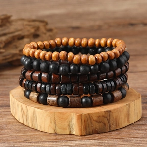 Detail of five-piece handmade wooden bead bracelets on a natural round wood base
