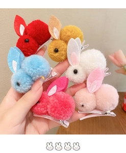 Gros plan de barrettes à cheveux lapin en peluche colorées en rouge, bleu et rose