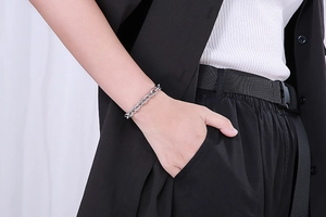 Close-up of silver OT buckle chain bracelet worn on wrist with minimalist metal design