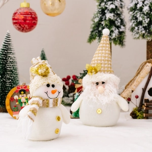 Detail of Christmas snowman and gnome plush dolls with gold knit hats and festive decor