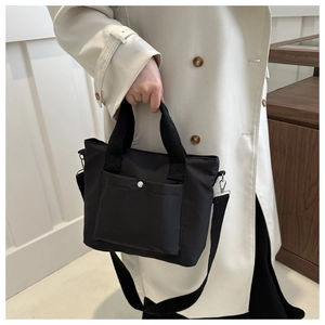 Detalle del bolso de nailon negro con bolsillo con hebilla plateada y correa ajustable