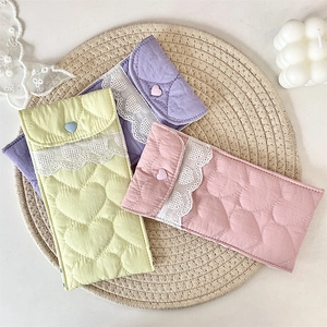 Quilted heart-patterned eyewear pouches in soft pastel colors with lace trim and button closure