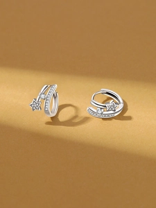 Macro detail of silver star hoop earrings with micro-paved cubic zirconia accents