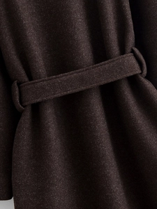Macro shot of dark brown wool coat showing waist belt detail and textured fabric
