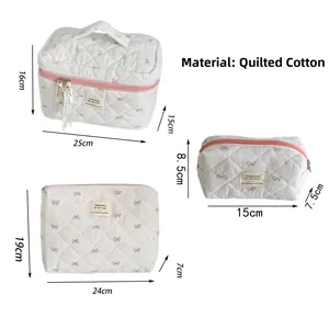 Ensemble détaillé de trois trousses de maquillage en coton matelassé à nœuds roses
