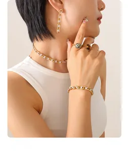 Detail of luxury gold chain jewelry set with zircon necklace, bracelet, and vintage rings