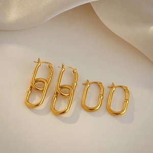 Detail of 18K gold-plated U-shaped stainless steel earrings on a smooth silk fabric