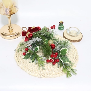 Christmas teardrop swag with red berries, pine needles, and a velvet bow on straw mat