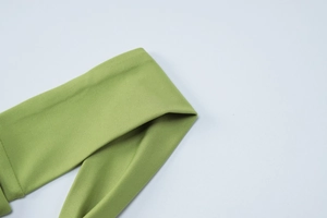 Close-up detail of grass green ribbed knit fabric texture for summer two-piece set