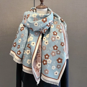 Detail of light blue vintage floral scarf with brown patterns and elegant fringe tassels