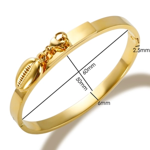 Detailed view of gold bangle dimensions 60x50mm with shell charm and lobster clasp