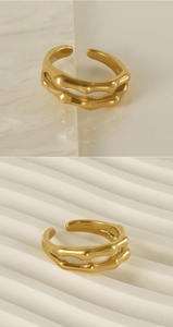 Dettaglio anello a doppio strato trama bambù oro 18K su superficie in marmo bianco