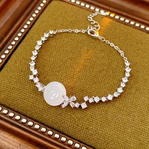 Macro detail of silver-tone chalcedony bracelet with zircon stones on green velvet