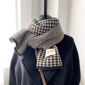 Detail of knit wool scarf featuring classic black and white houndstooth and herringbone patterns