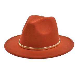 Detail of rust red wool jazz hat with elegant gold band and classic teardrop crown